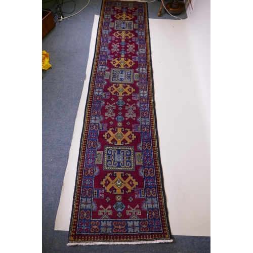 1092 - A claret wine ground wool caucasian runner with bespoke medallion design in unique colours, 322 x 73... 