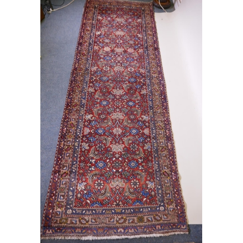 1094 - A hand woven red ground Persian Hamadan nomadic runner with an allover floral design, 102 x 310cm