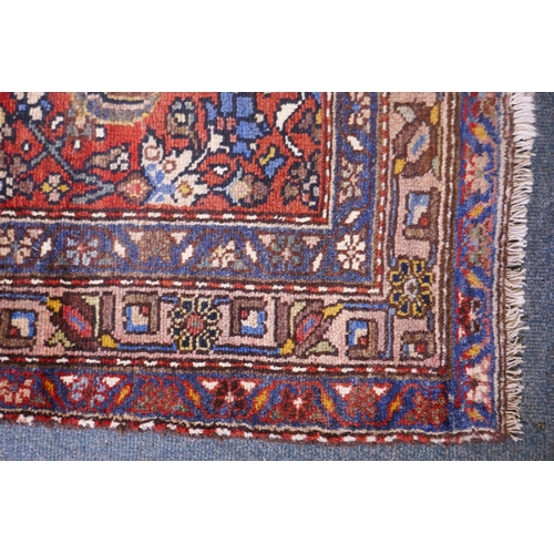 1094 - A hand woven red ground Persian Hamadan nomadic runner with an allover floral design, 102 x 310cm