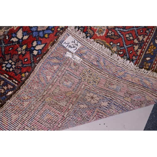 1094 - A hand woven red ground Persian Hamadan nomadic runner with an allover floral design, 102 x 310cm