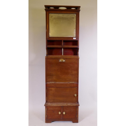 1103 - A mahogany ship's cabin wash stand cabinet, the reservoir behind the mirror, with fall front and fol... 