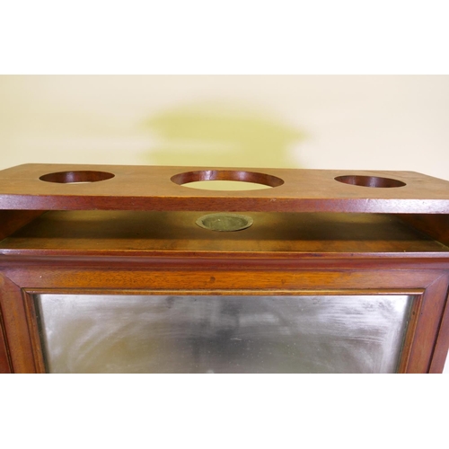 1103 - A mahogany ship's cabin wash stand cabinet, the reservoir behind the mirror, with fall front and fol... 