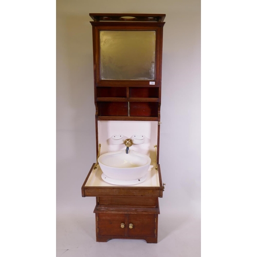 1103 - A mahogany ship's cabin wash stand cabinet, the reservoir behind the mirror, with fall front and fol... 