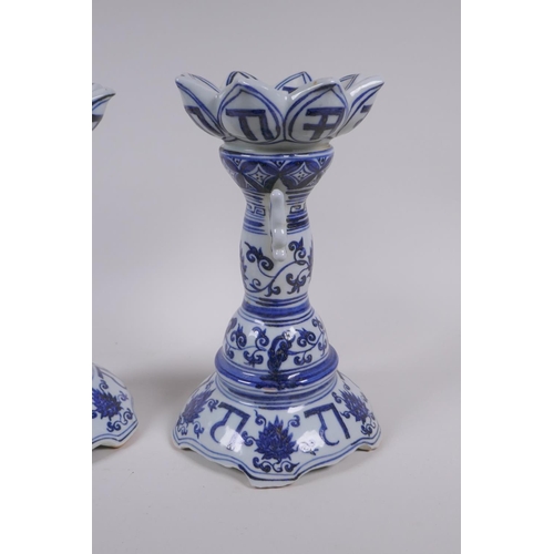 111 - A pair of Chinese blue and white porcelain candlesticks of lotus flower form, with two handles and c... 