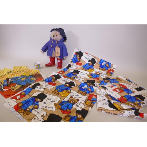 120 - A Paddington Bear by Gabrielle designs, AF tatty coat, two aprons and a mug, and five Paddington's A... 