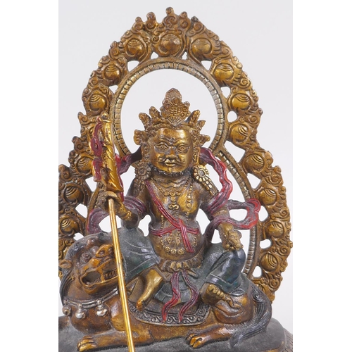 121 - A Sino Tibetan painted bronze figure of a deity seated on a mythical creature, 4 character mark to b... 