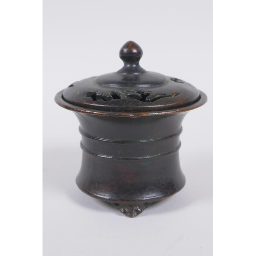 130 - A Chinese bronze censer and cover with a ribbed body and tripod supports, impressed seal mark to bas... 