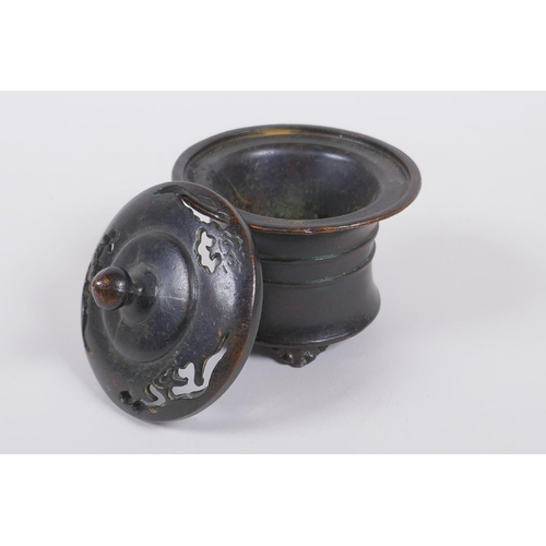 130 - A Chinese bronze censer and cover with a ribbed body and tripod supports, impressed seal mark to bas... 