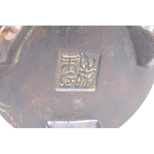 130 - A Chinese bronze censer and cover with a ribbed body and tripod supports, impressed seal mark to bas... 