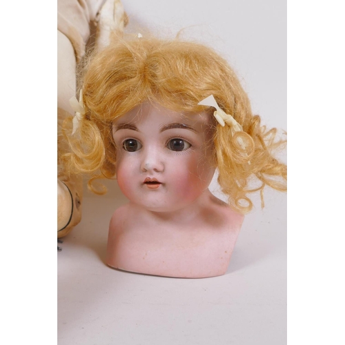 134 - An antique German Bisque dolls head with open and shut eyes, and an associated torso, the head marke... 