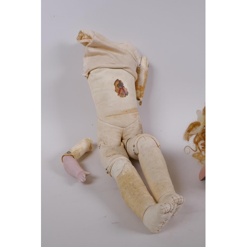 134 - An antique German Bisque dolls head with open and shut eyes, and an associated torso, the head marke... 