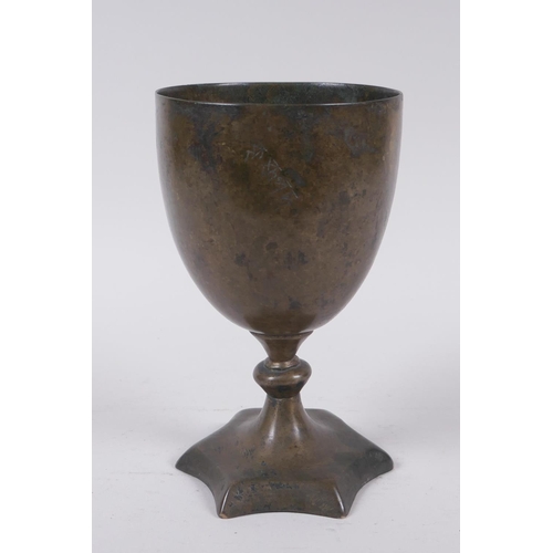 14 - An early Nepalese/Tibetan bronze chalice with a star shaped foot and archaic inscriptions, 17cm high