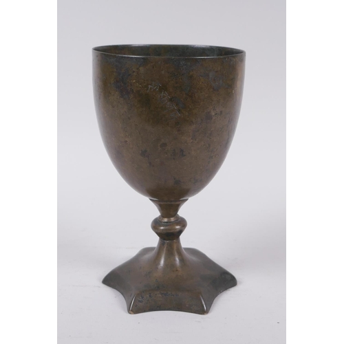 14 - An early Nepalese/Tibetan bronze chalice with a star shaped foot and archaic inscriptions, 17cm high