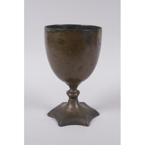 14 - An early Nepalese/Tibetan bronze chalice with a star shaped foot and archaic inscriptions, 17cm high