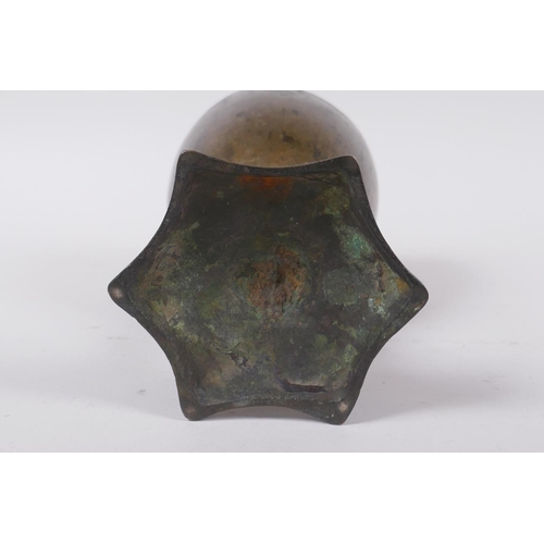 14 - An early Nepalese/Tibetan bronze chalice with a star shaped foot and archaic inscriptions, 17cm high