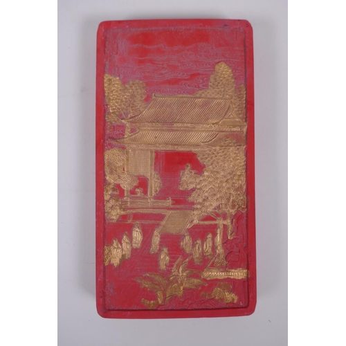 143 - A Chinese red ink stone with raised and gilt decoration of figures in a palace, character marks vers... 