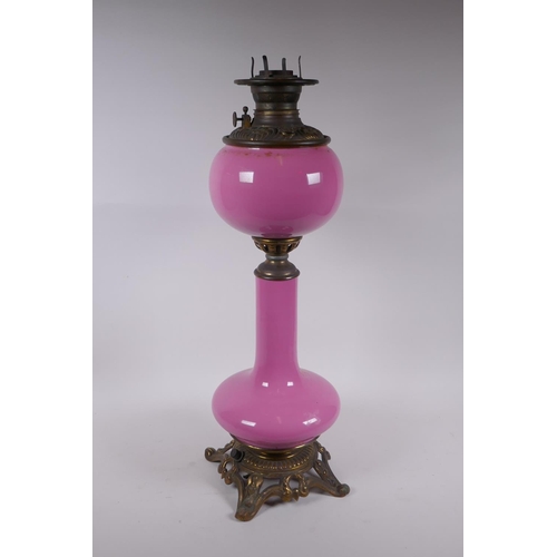 154 - A pink glass and brassed metal oil lamp converted to electricity, 64cm high