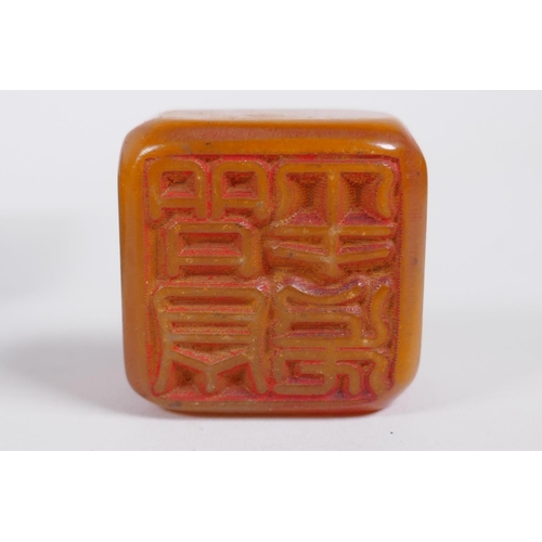 155 - A Chinese hardstone box with carved lotus flower decoration to the cover, containing an amber soapst... 