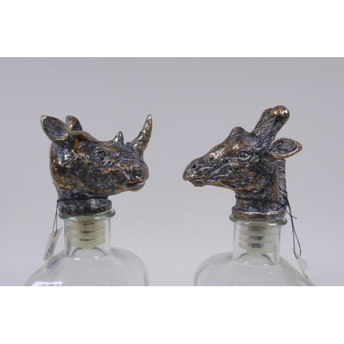 162 - A pair of glass decanters with gilt composition stoppers in the form of animal heads, 25cm high