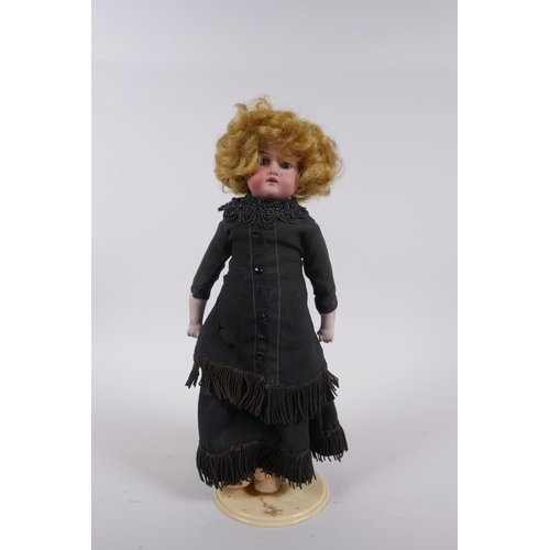 172 - An antique German Armand Marseille bisque headed doll in a black dress, marked A.M. 370 9/0, 30cm hi... 