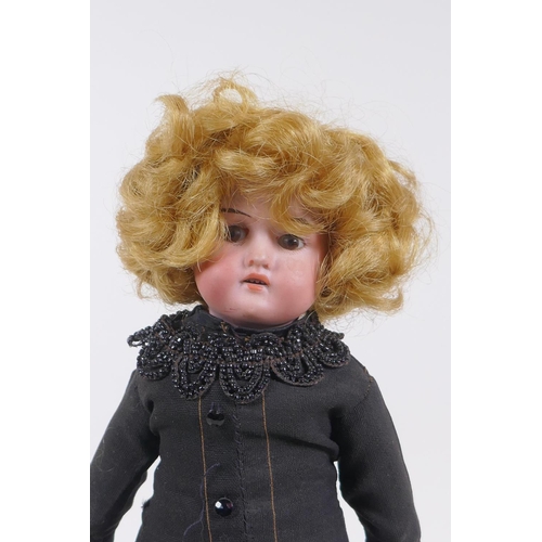 172 - An antique German Armand Marseille bisque headed doll in a black dress, marked A.M. 370 9/0, 30cm hi... 