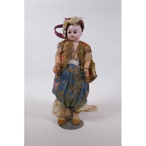 174 - An antique bisque headed doll in Arabian clothing, marked to the back of the neck C10/0, 30cm high