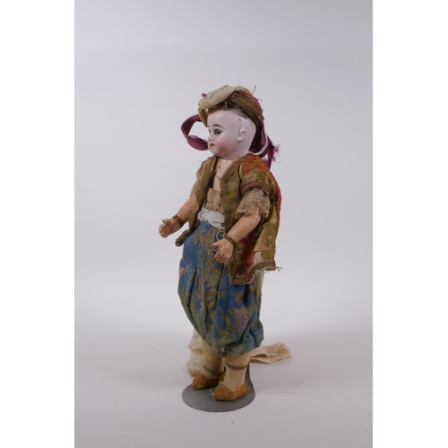 174 - An antique bisque headed doll in Arabian clothing, marked to the back of the neck C10/0, 30cm high