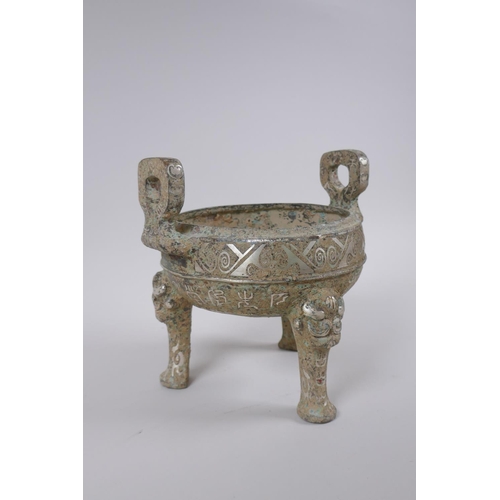 178 - A Chinese archaic style metal censer with two handles, tripod supports and silvered metal decoration... 