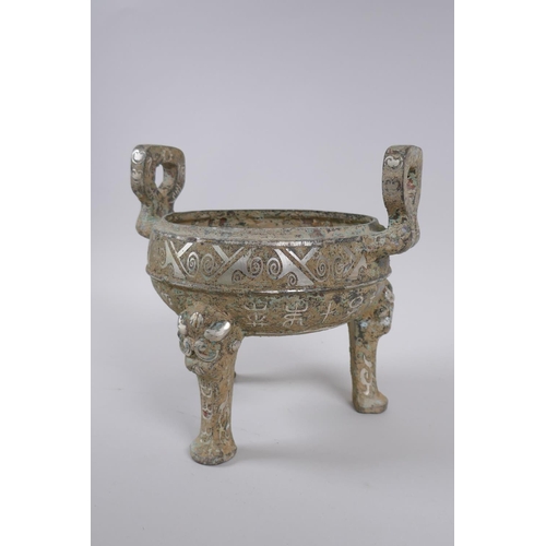 178 - A Chinese archaic style metal censer with two handles, tripod supports and silvered metal decoration... 