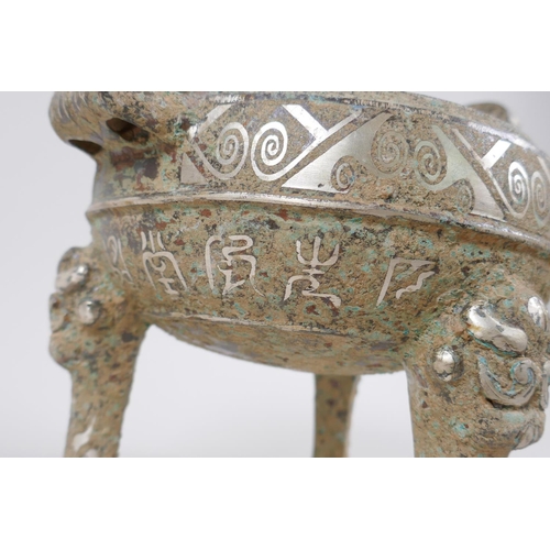 178 - A Chinese archaic style metal censer with two handles, tripod supports and silvered metal decoration... 