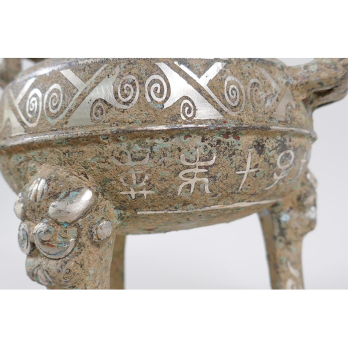 178 - A Chinese archaic style metal censer with two handles, tripod supports and silvered metal decoration... 