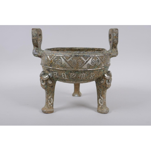 178 - A Chinese archaic style metal censer with two handles, tripod supports and silvered metal decoration... 