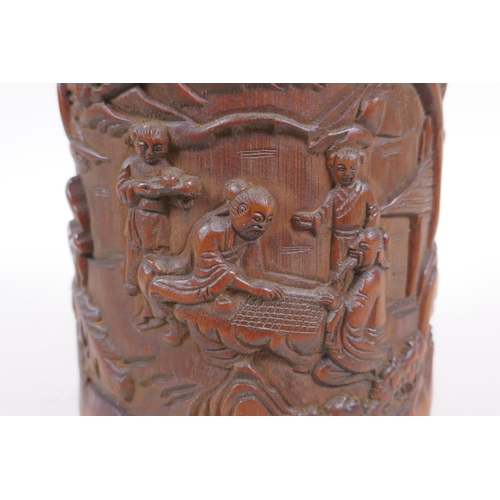 181 - A Chinese carved bamboo brush pot decorated with figures playing go, 16cm high