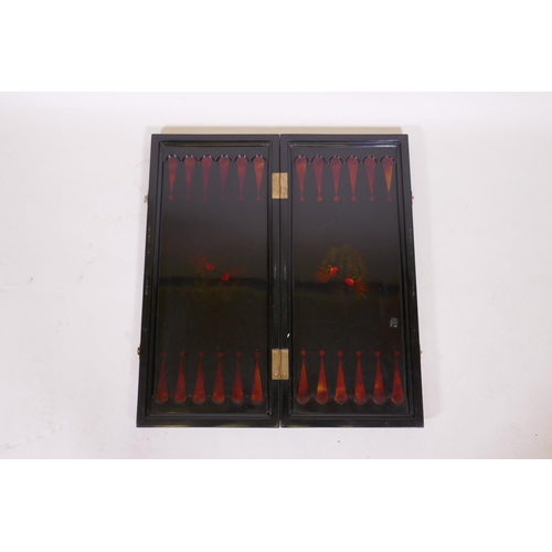 187 - An oriental lacquered fold out games board with chequerboard and backgammon, with painted and gilded... 