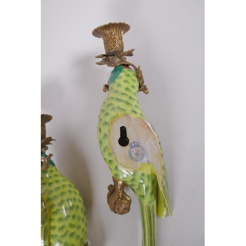 197 - A pair of polychrome porcelain parrot candle sconces with gilt metal mounts, 48cm