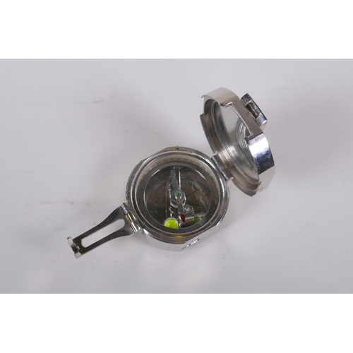 204 - A Brunton style white metal field compass, 6 x 6cm