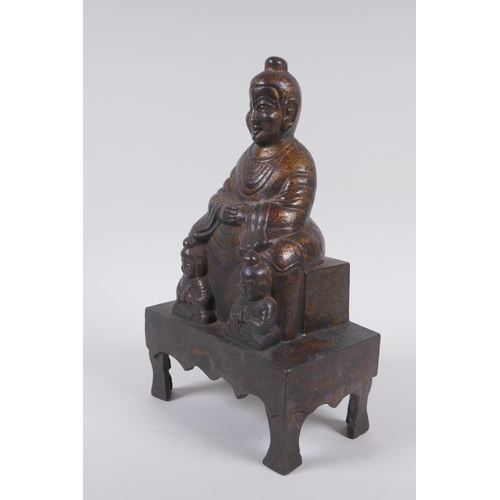 213 - A Chinese gilt bronze figure of Buddha seated on a throne, inscription verso, 26cm high