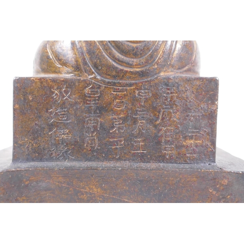 213 - A Chinese gilt bronze figure of Buddha seated on a throne, inscription verso, 26cm high