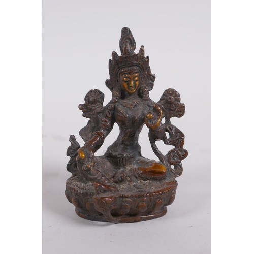 232 - A Tibetan bronze of a female deity seated on a lotus throne, 9cm high