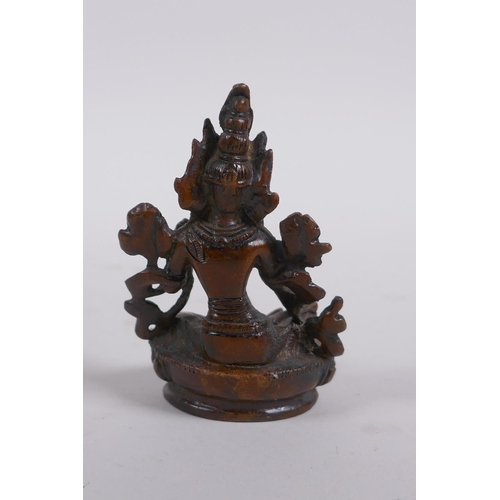 232 - A Tibetan bronze of a female deity seated on a lotus throne, 9cm high