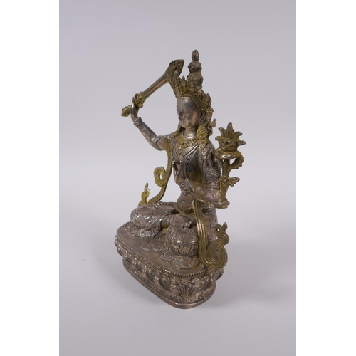 233 - A Tibetan silvered metal figure of Buddha, with gilt highlights, 22cm high