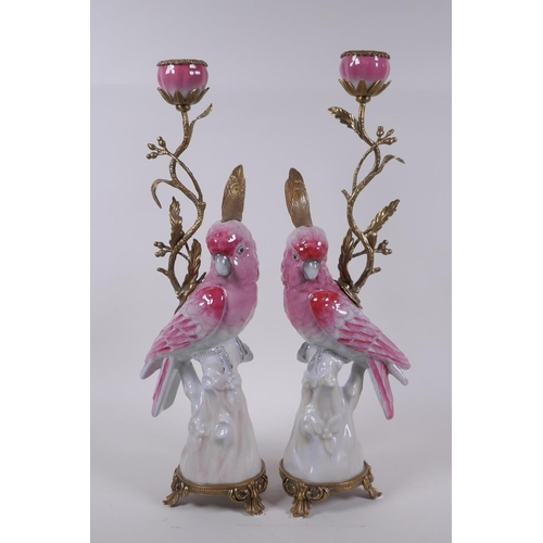 239 - A pair of porcelain and gilt metal pink cockatoo candlesticks, 41cm high