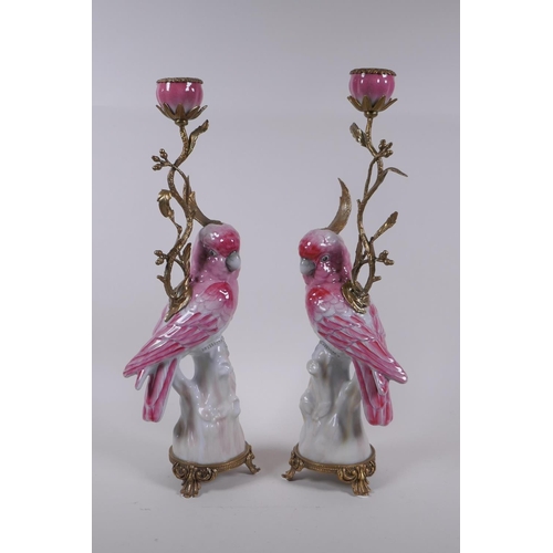 239 - A pair of porcelain and gilt metal pink cockatoo candlesticks, 41cm high