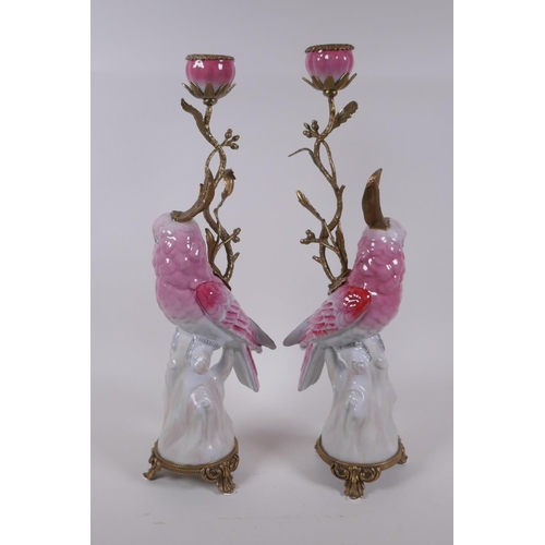 239 - A pair of porcelain and gilt metal pink cockatoo candlesticks, 41cm high