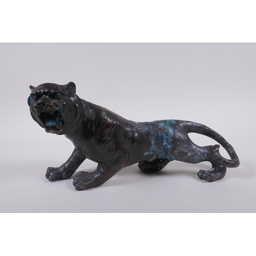 242 - An oriental filled bronzed figure of a tiger, 30cm long