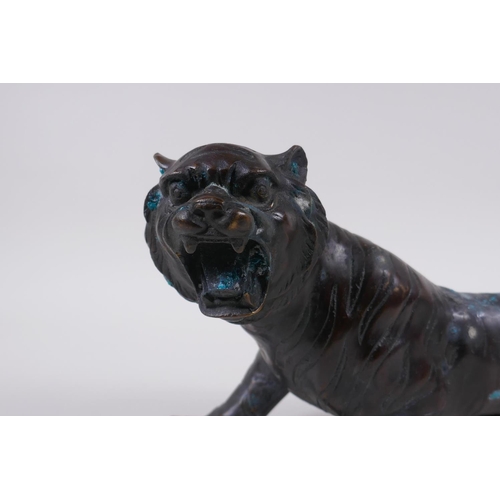 242 - An oriental filled bronzed figure of a tiger, 30cm long