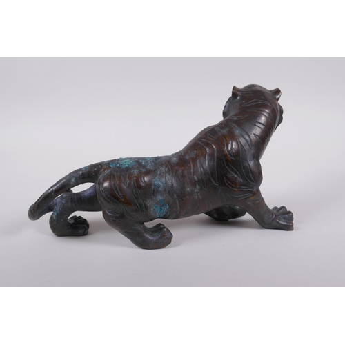 242 - An oriental filled bronzed figure of a tiger, 30cm long