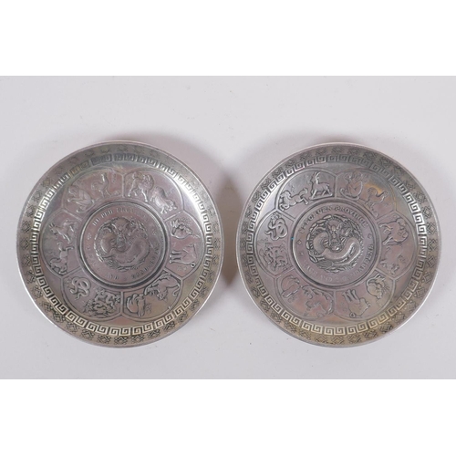 243 - A pair of Chinese white metal coin dishes with zodiac animal decoration