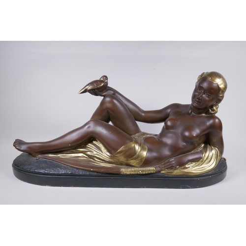 256 - A bronzed and gilt plaster figure of a reclining female nude, 75cm long, 35cm high