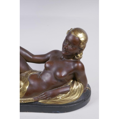 256 - A bronzed and gilt plaster figure of a reclining female nude, 75cm long, 35cm high